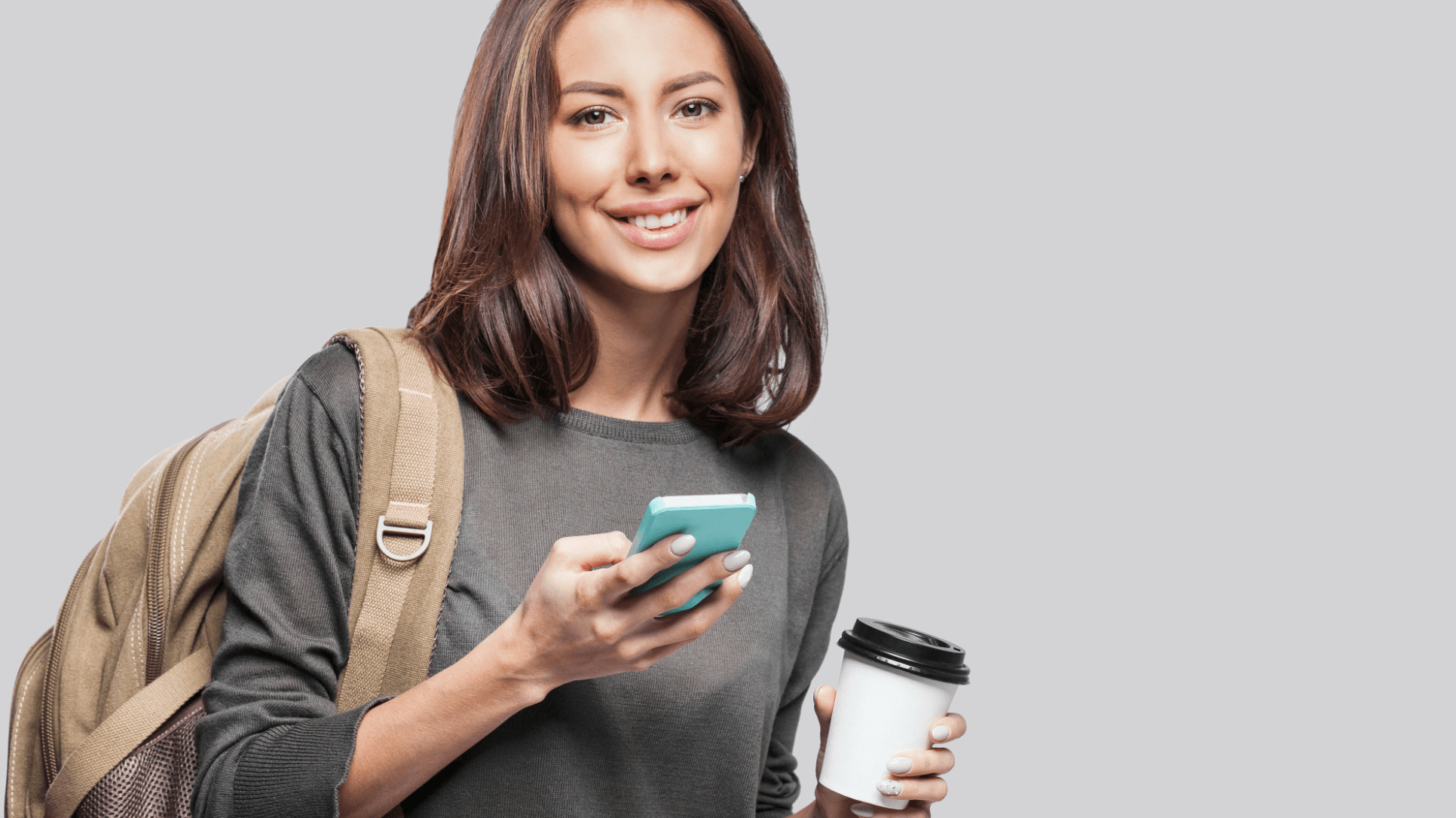 woman smiling with phone and coffee in hand